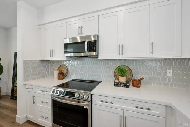 a kitchen with appliances a sink and cabinets