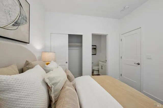 a bedroom with a bed and a painting on the wall