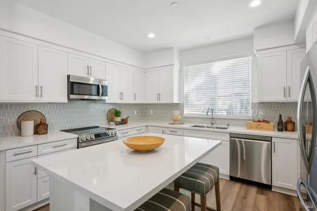 a kitchen with a sink a stove cabinets and wooden floor