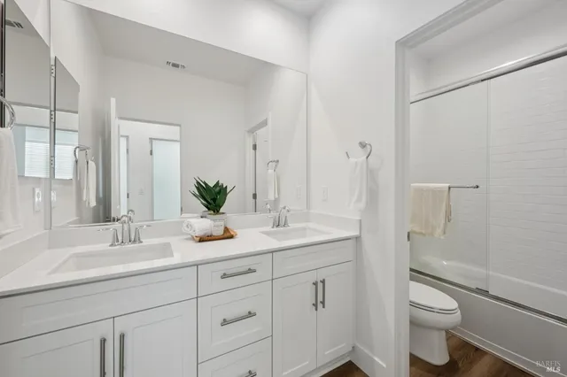 a bathroom with a granite countertop sink a toilet and a mirror