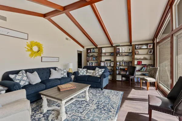 a kitchen with stainless steel appliances kitchen island granite countertop a refrigerator a stove top oven a sink a dining table and chairs