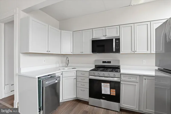 a kitchen with white cabinets and stainless steel appliances
