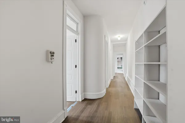 a view of a hallway with wooden floor and closet