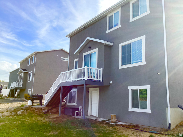 Stucco exterior with white trim windows and a white baluster deck
