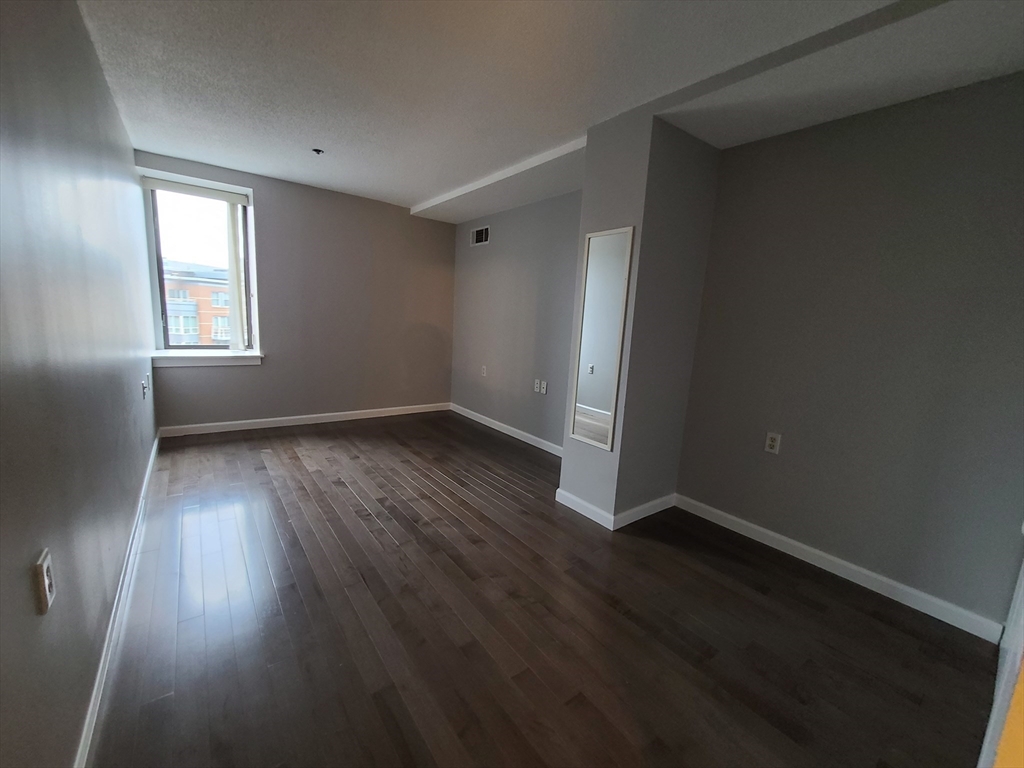 357 Commercial Street, Unit 507 Boston, MA 02109 - Photo 12 of 22 an empty room with wooden floor and windows