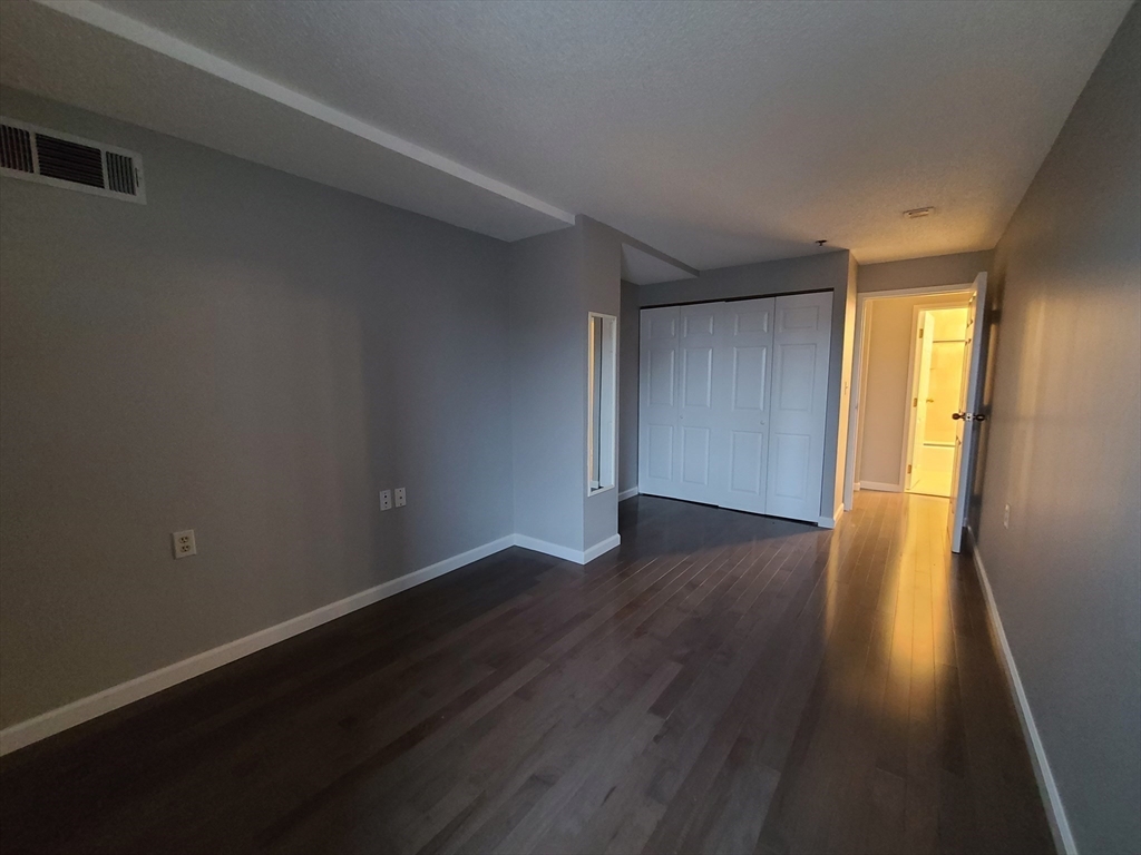 357 Commercial Street, Unit 507 Boston, MA 02109 - Photo 13 of 22 a view of an empty room with wooden floor and a window