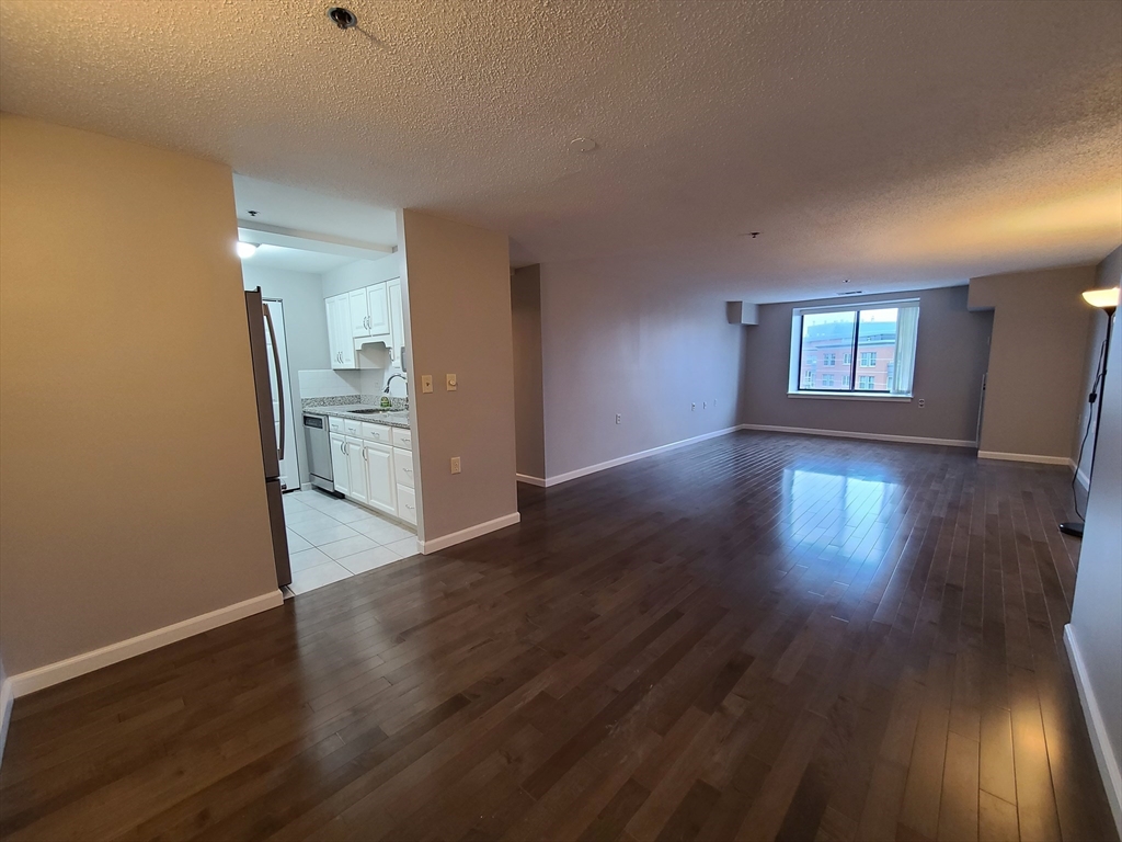 357 Commercial Street, Unit 507 Boston, MA 02109 - Photo 2 of 22 an empty room with wooden floor and windows