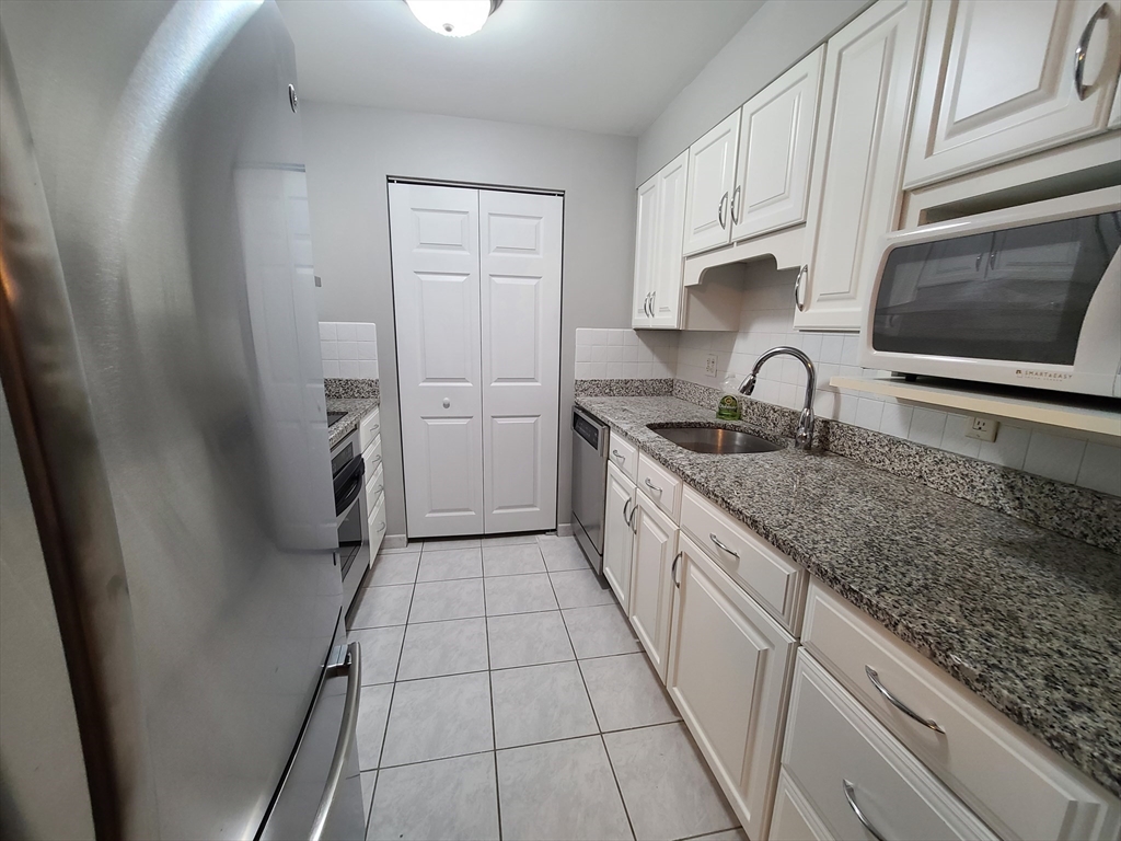 357 Commercial Street, Unit 507 Boston, MA 02109 - Photo 3 of 22 a kitchen with a sink stove and cabinets