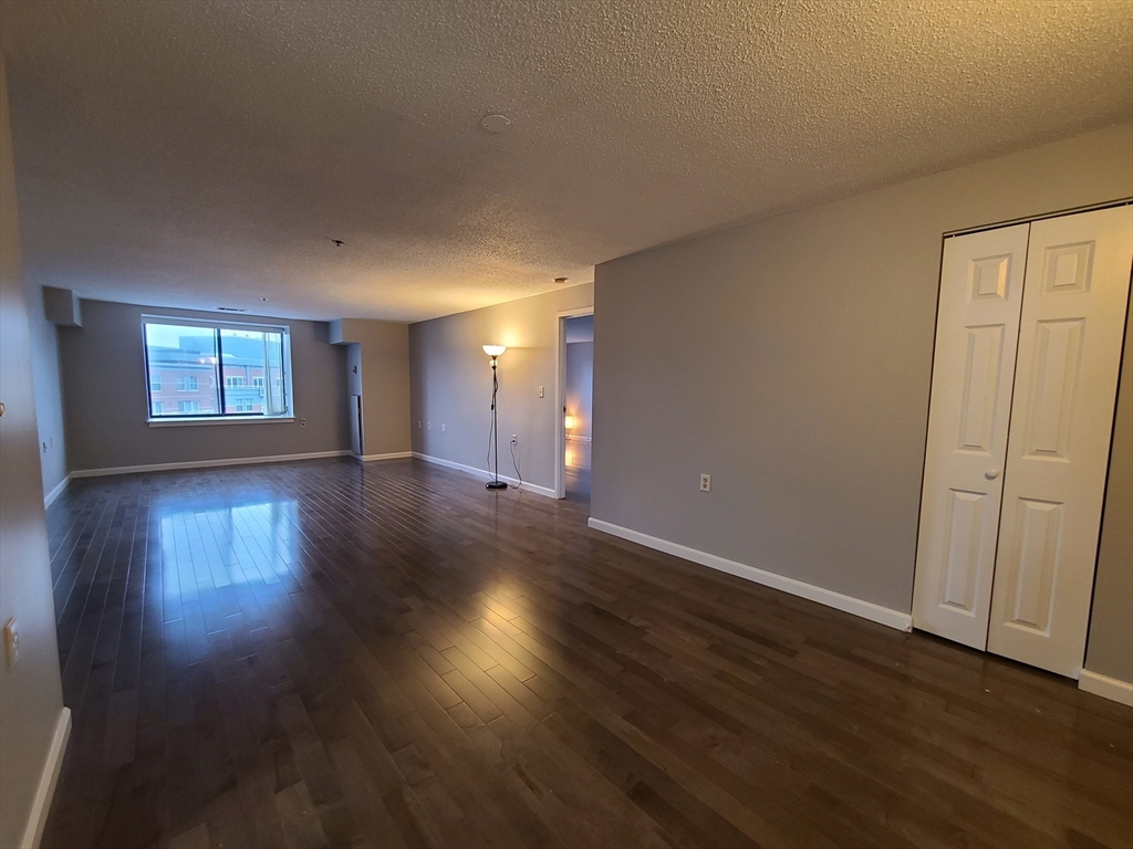 357 Commercial Street, Unit 507 Boston, MA 02109 - Photo 6 of 22 a view of an empty room with wooden floor and a window