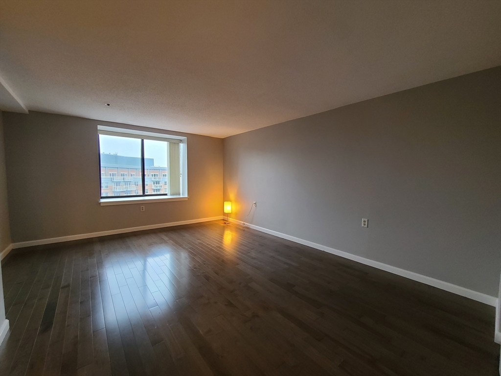 357 Commercial Street, Unit 507 Boston, MA 02109 - Photo 9 of 22 an empty room with wooden floor and windows