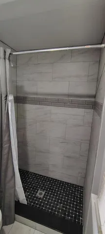 an empty room with wooden floor chandelier and windows