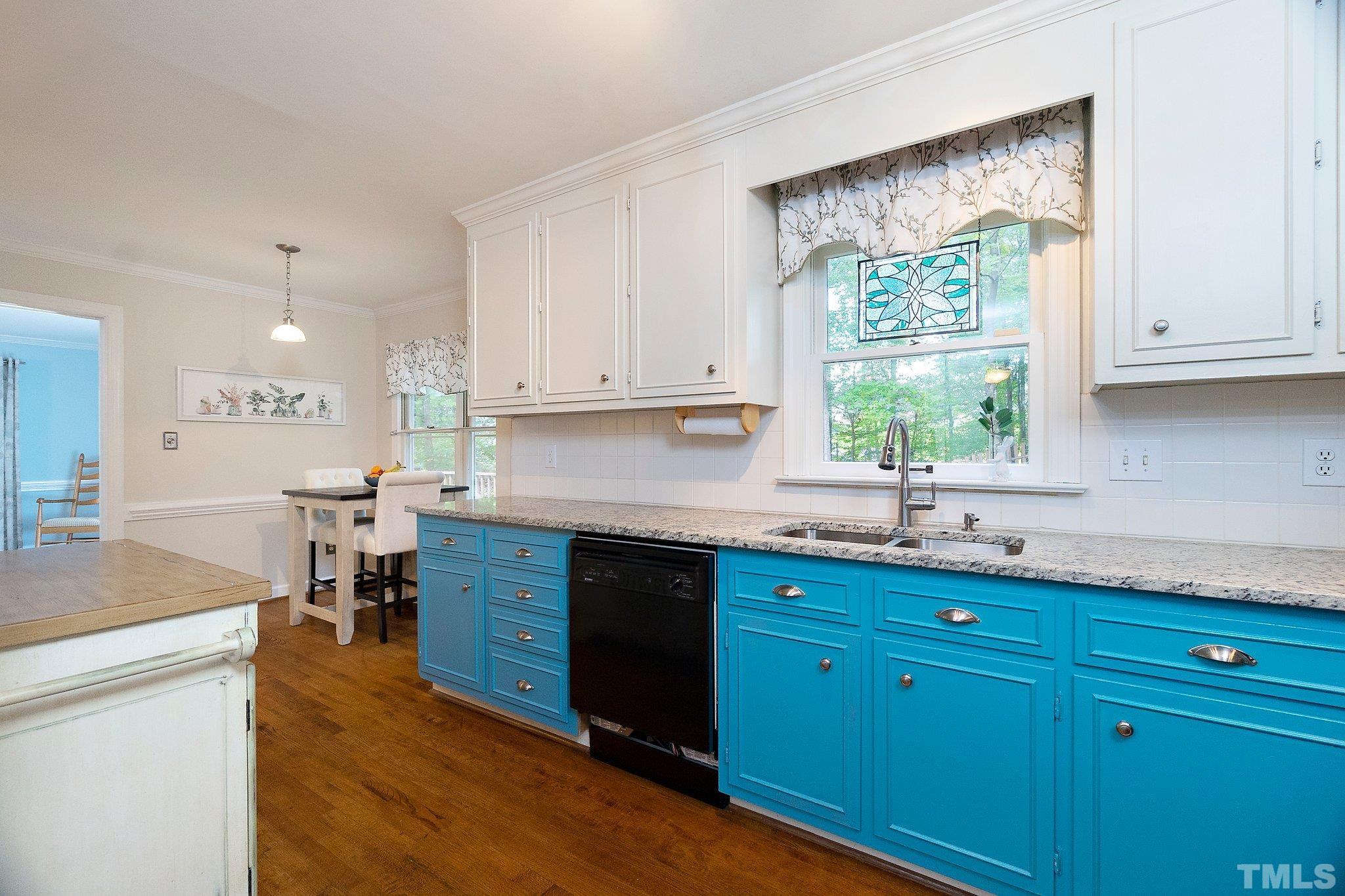 612 Morningside Drive Durham, NC 27713 - Photo 17 of 36 a kitchen with stainless steel appliances granite countertop wooden cabinets a sink a stove a dining table and chairs with wooden floor