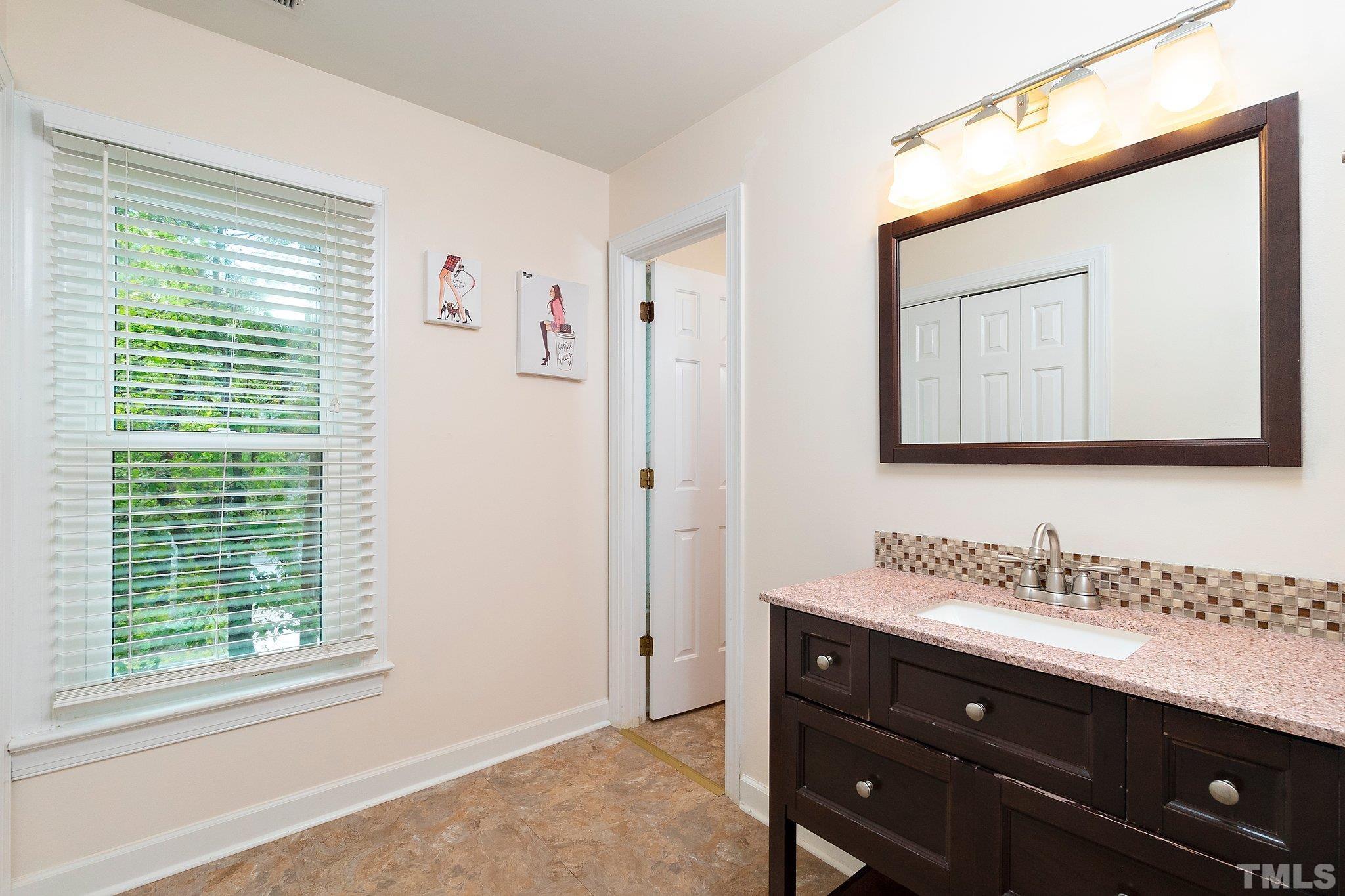 612 Morningside Drive Durham, NC 27713 - Photo 27 of 36 a bathroom with a sink a mirror and a window