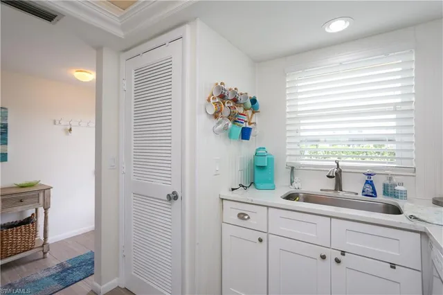 a kitchen with white cabinets and a window