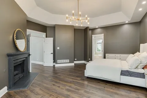 a spacious bedroom with a bed and a chandelier