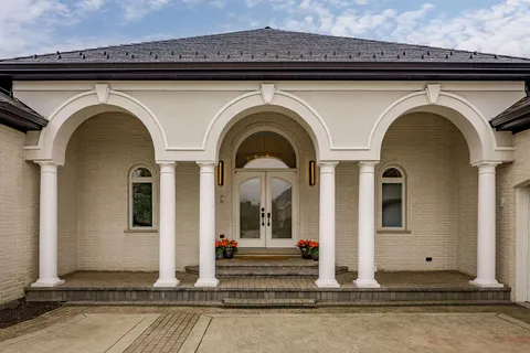a view of a grey house with large windows