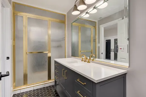 a bathroom with a sink vanity granite and a mirror