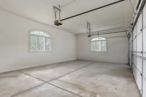 an empty room with windows and ceiling fan