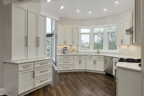 a kitchen with granite countertop cabinets and wooden floor
