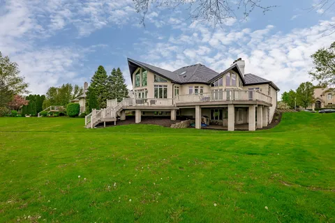 a front view of a house with a big yard and large trees
