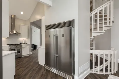 a view of a kitchen with wooden floor and electronic appliances