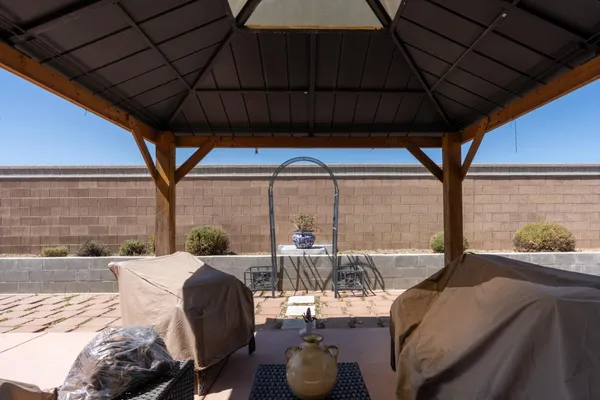 a view of a patio with table and chairs under an umbrella