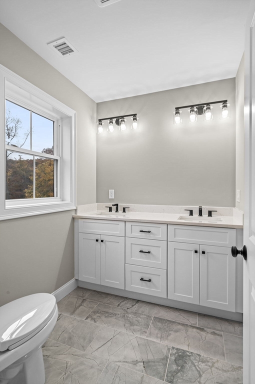 9 Acton Road, Unit 6 Chelmsford, MA 01824 - Photo 16 of 20 a spacious bathroom with a mirror and a toilet