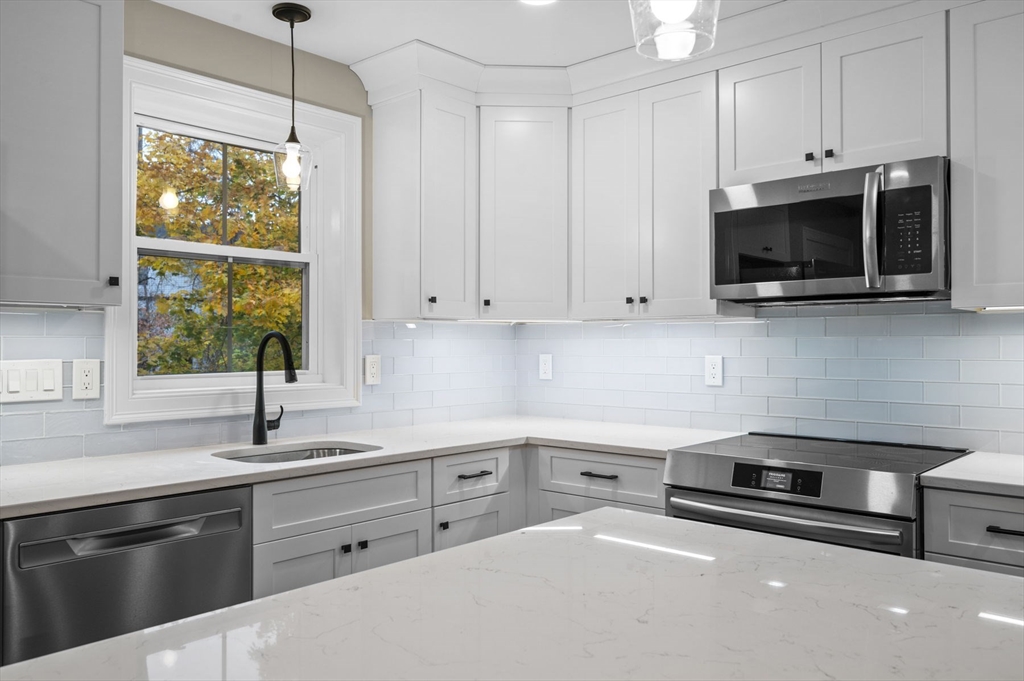 9 Acton Road, Unit 6 Chelmsford, MA 01824 - Photo 10 of 21 a kitchen with stainless steel appliances white cabinets a sink and a stove