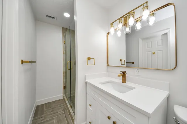 a bathroom with a sink shower and a mirror