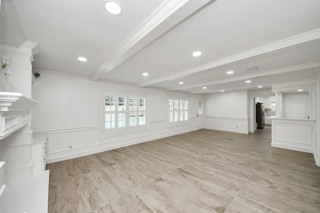 a view of an empty room with a chandelier fan