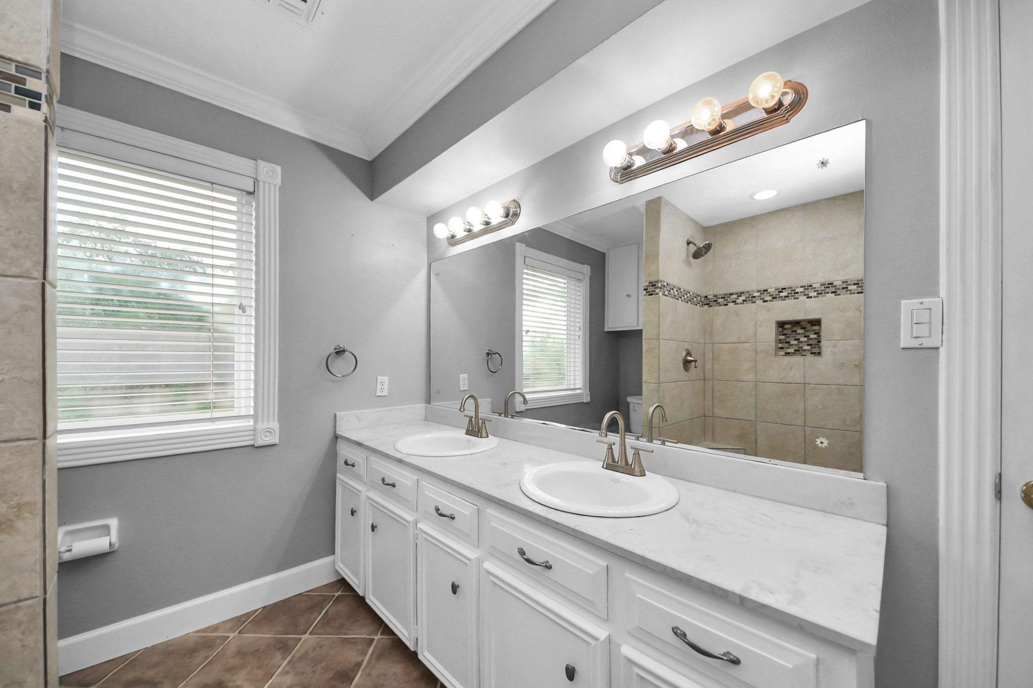 1719 Saddlecreek Drive Houston, TX 77090 - Photo 21 of 38 a bathroom with a granite countertop sink a large mirror and a shower