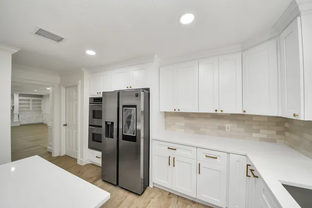 a kitchen with stainless steel appliances granite countertop a sink a stove and a refrigerator