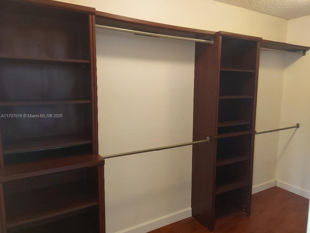 20033 Northeast 2nd Place, Unit 20033 Miami, FL 33179 - Photo 11 of 26 a view of walk in closet with empty racks