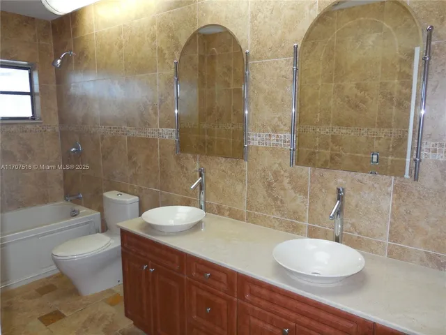 a bathroom with a granite countertop sink toilet a mirror and shower
