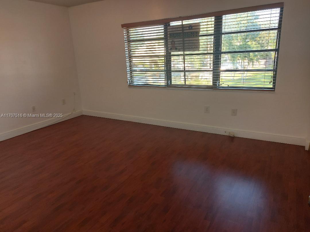 20033 Northeast 2nd Place, Unit 20033 Miami, FL 33179 - Photo 17 of 26 an empty room with wooden floor and windows