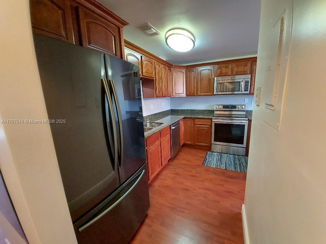 20033 Northeast 2nd Place, Unit 20033 Miami, FL 33179 - Photo 4 of 26 a kitchen with stainless steel appliances granite countertop a refrigerator a stove and a sink