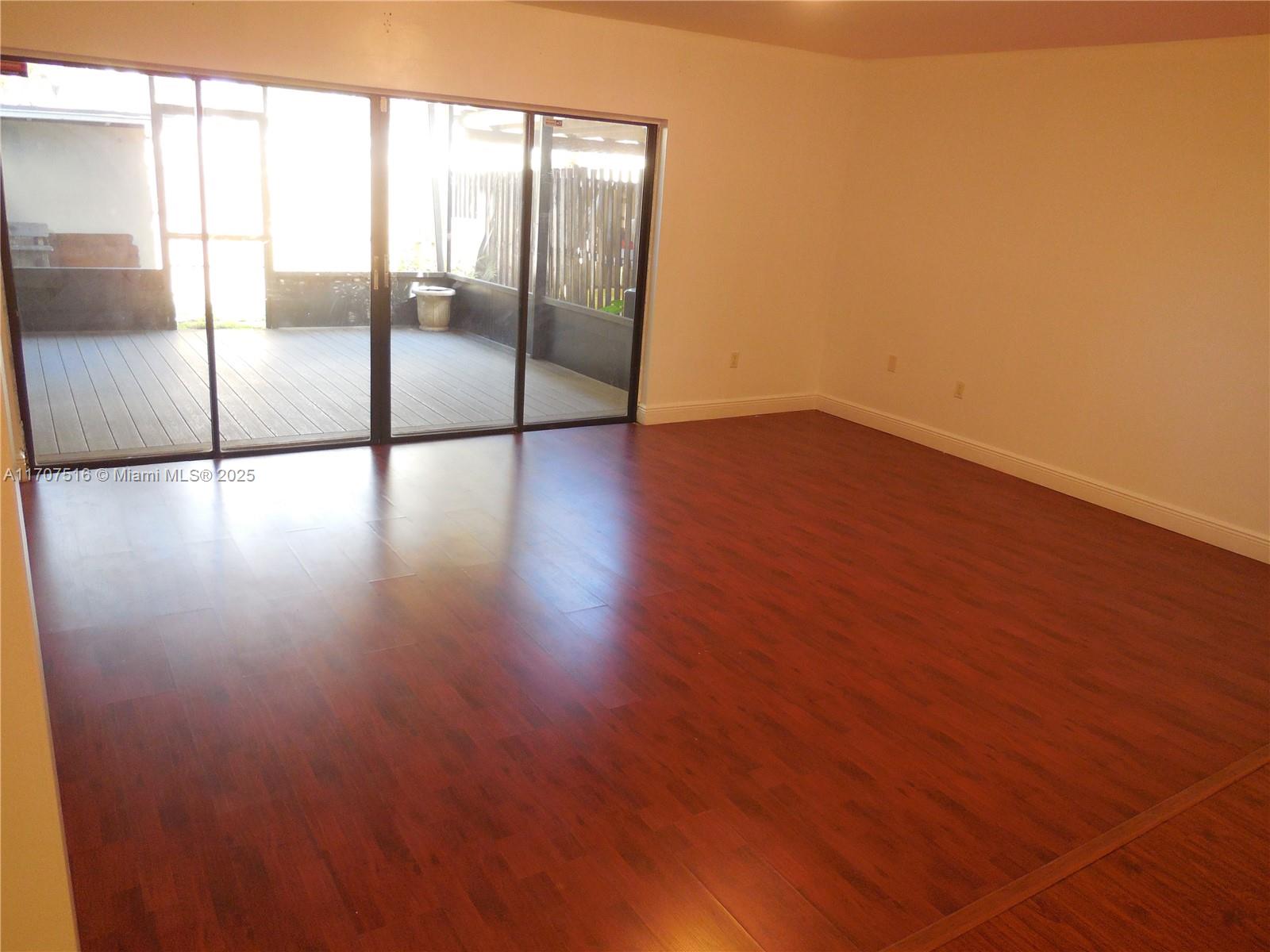 20033 Northeast 2nd Place, Unit 20033 Miami, FL 33179 - Photo 6 of 26 an empty room with wooden floor and windows