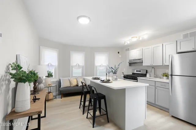 a living room with kitchen island furniture a counter space and white appliances