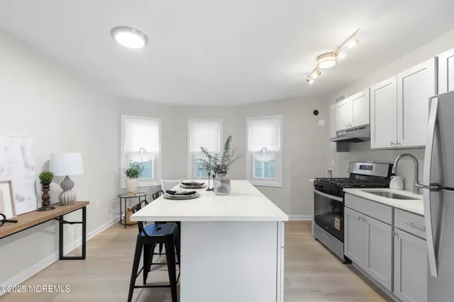 a kitchen with sink refrigerator and microwave