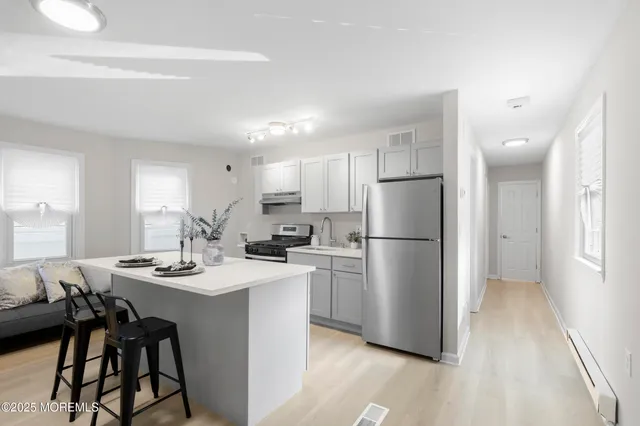 a kitchen with a refrigerator a stove a dining table and chairs