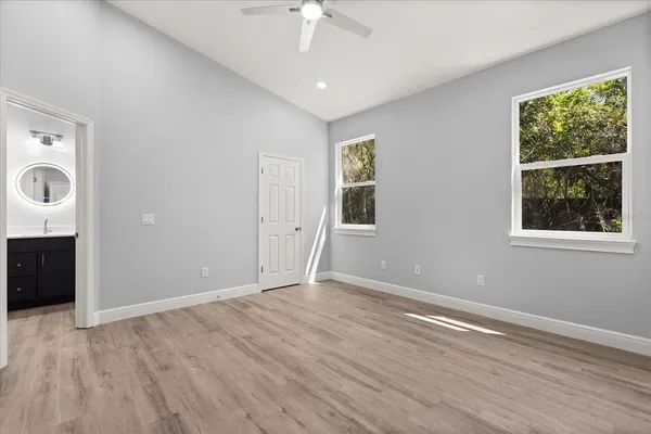 a view of an empty room with a window and wooden floor