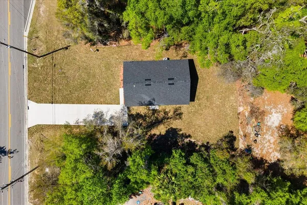an aerial view of a residential houses with yard