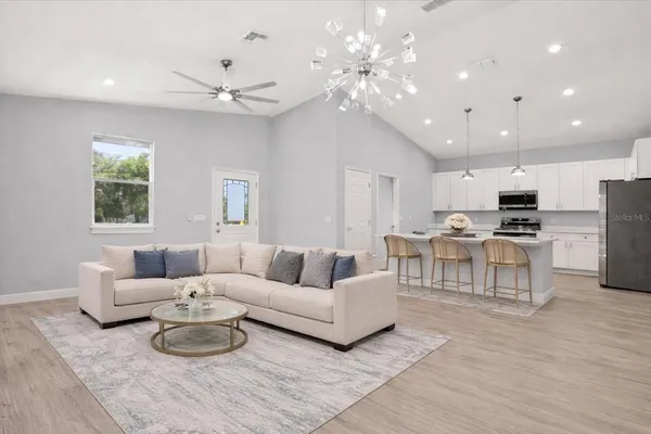 a living room with furniture kitchen and a chandelier