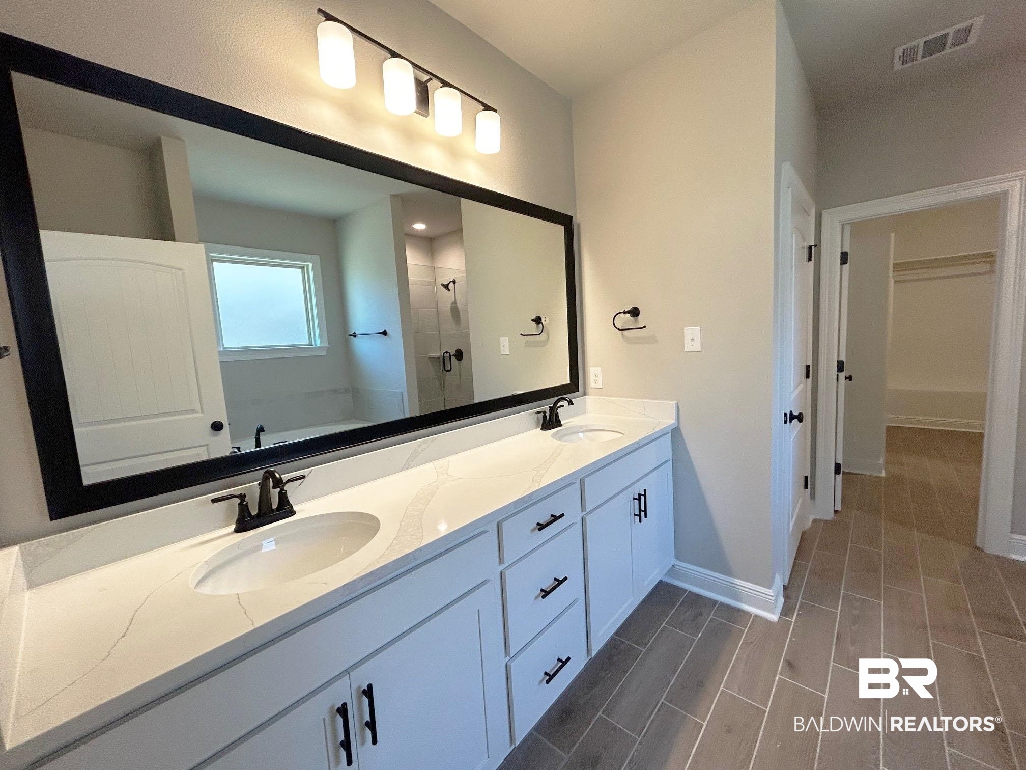 877 Sumter Loop Foley, AL 36535 - Photo 8 of 18 Bathroom featuring a sink, visible vents, wood finish floors, and a stall shower