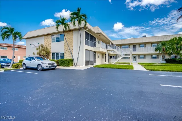 a view of a white house with a swimming pool yard and deck
