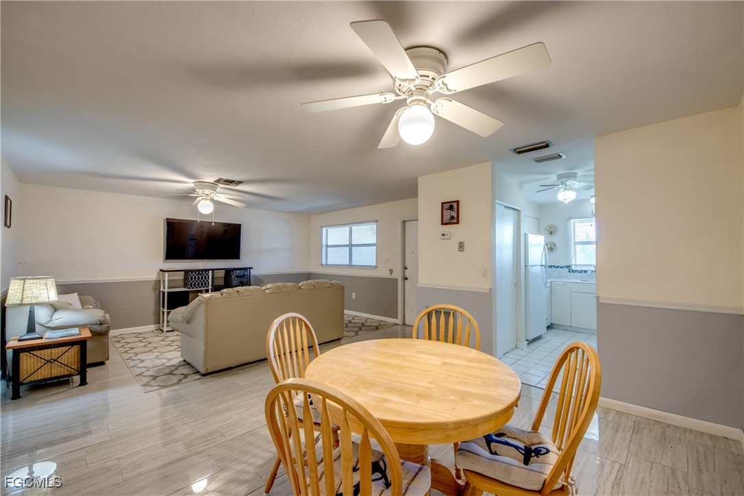 909 Southeast 46th Lane, Unit 202 Cape Coral, FL 33904 - Photo 12 of 38 a living room with furniture a flat screen tv and kitchen view
