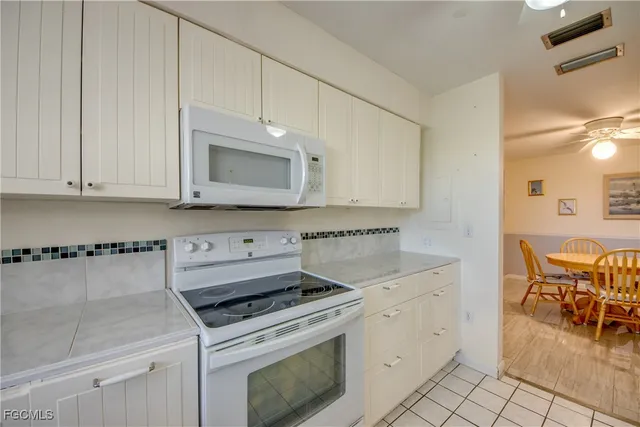 a kitchen with cabinets appliances and a wooden floor
