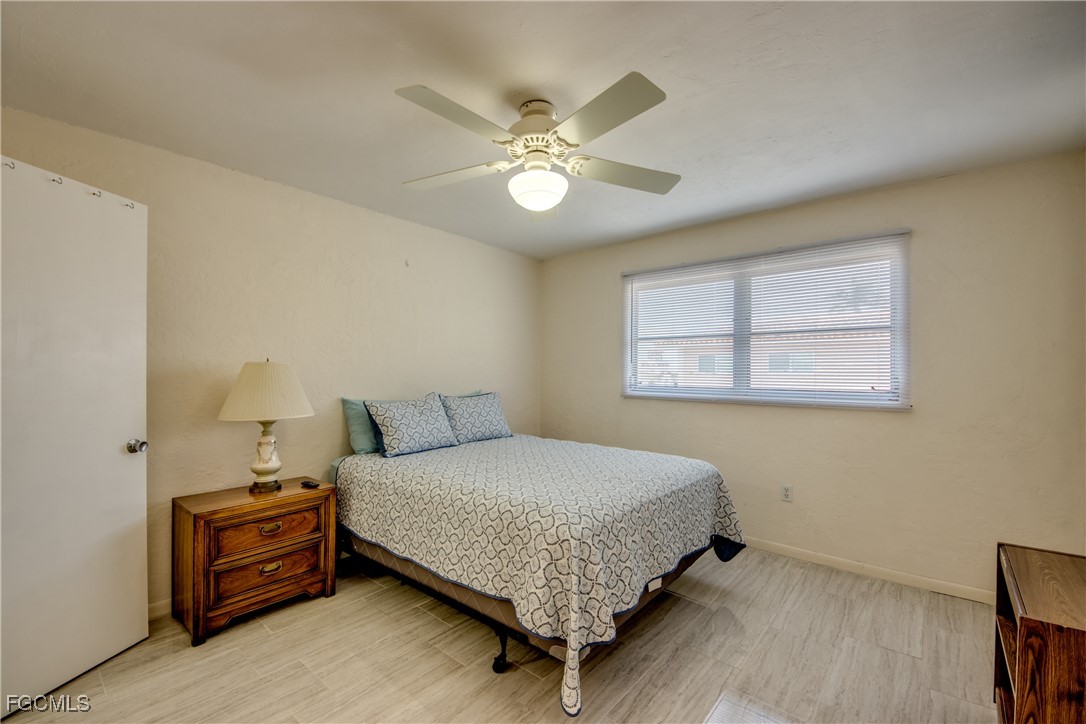 909 Southeast 46th Lane, Unit 202 Cape Coral, FL 33904 - Photo 18 of 38 a bedroom with a bed and a chandelier