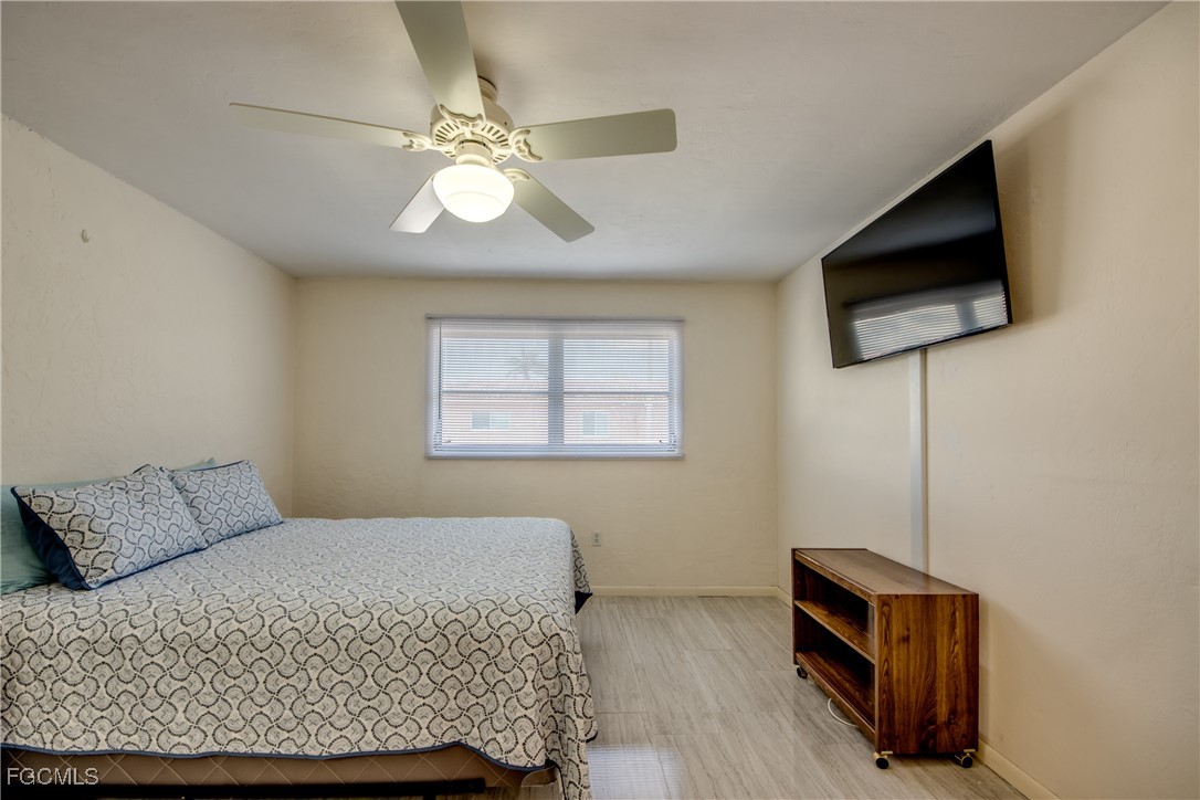 909 Southeast 46th Lane, Unit 202 Cape Coral, FL 33904 - Photo 19 of 38 a bedroom with a bed and a flat screen tv