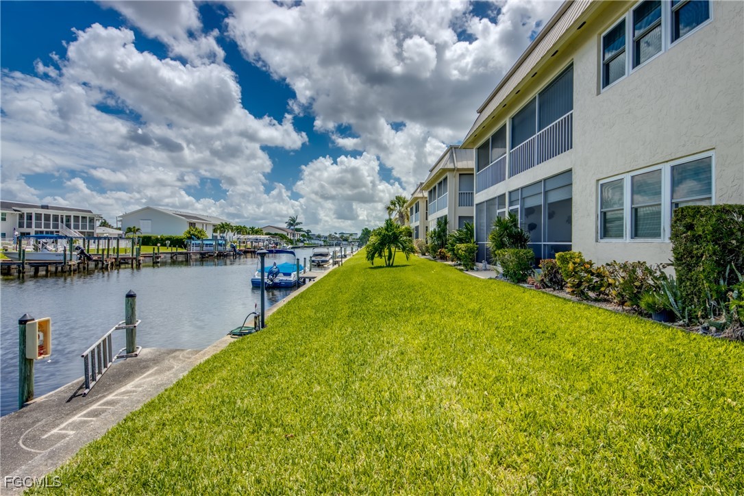 909 Southeast 46th Lane, Unit 202 Cape Coral, FL 33904 - Photo 29 of 38 a view of a lake with a house in the background